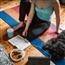 Woman on yoga mat surrounded by music pet and coffee