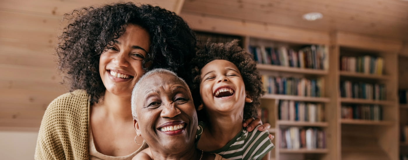 Three women of different ages smiling.