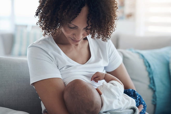 female feeding newborn baby