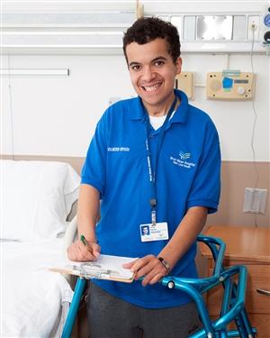 Bryn Mawr Hospital volunteer in a hospital room with clipboard