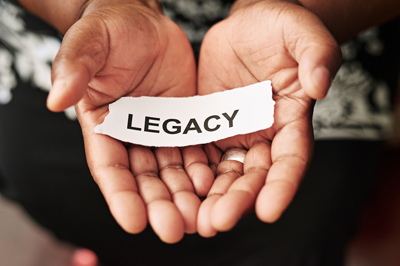 Cropped shot of a woman holding a piece of paper with the word “legacy” on it