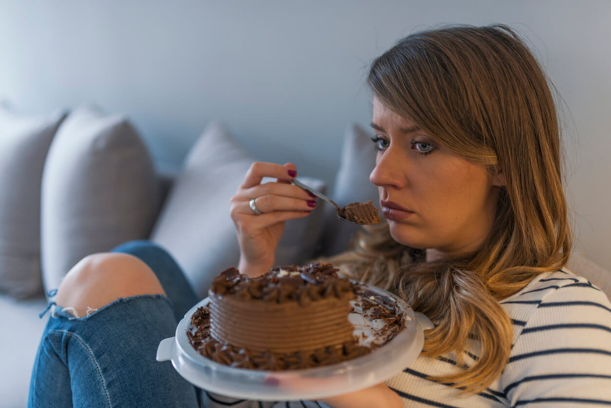 woman emotional eating of chocolate cake