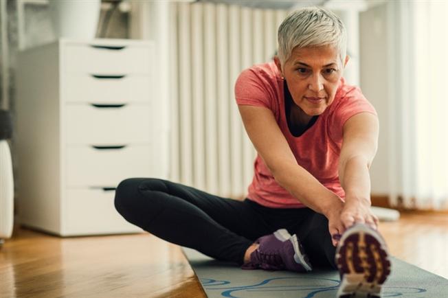 Older woman stretching on a yoga mat