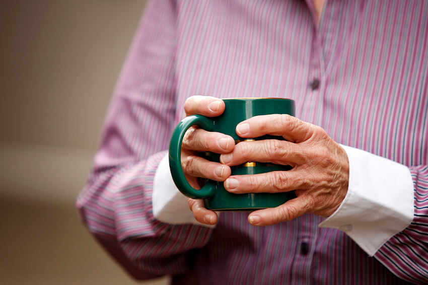 Older hands holding a mug
