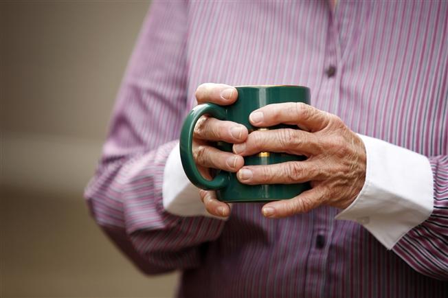 Older hands holding a mug