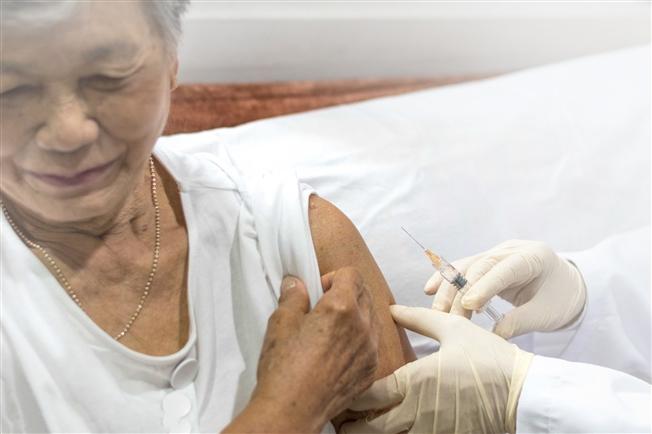 Woman getting vaccine in arm Woman getting vaccine in arm