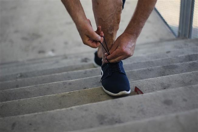 Close up of varicose vein on man tying shoe