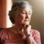 Mature woman looking sadly to the side with her hand under her chin