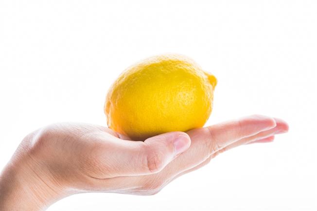 A hand holding a lemon