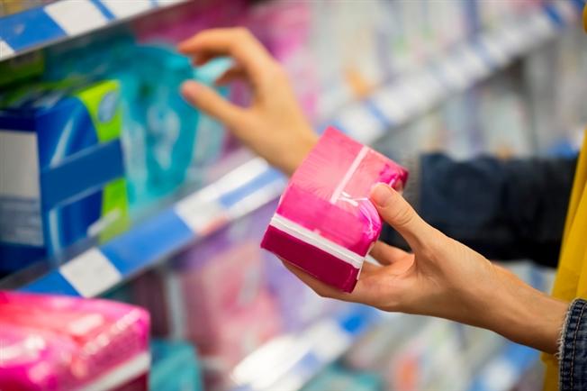 lady checking out pantyliner packages in the hygiene isle at the store lady checking out pantyliner packages in the hygiene isle at the store