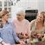 three generations of women preparing food in a kitchen