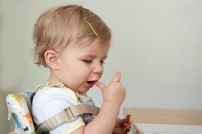 young child strapped in a high chair