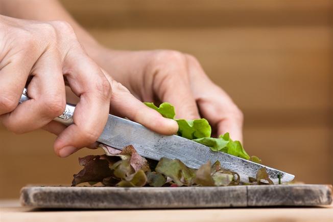 herbs being chopped on a cutting board