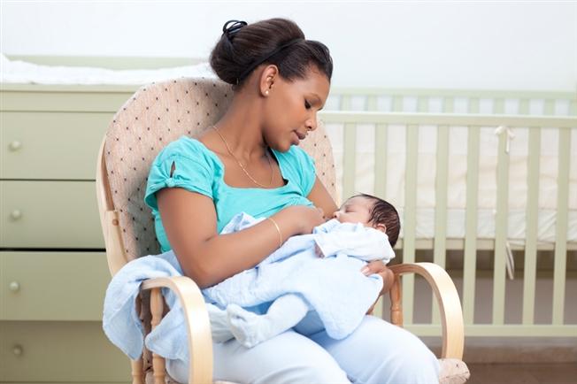mother sitting in rocking chair with baby in lap