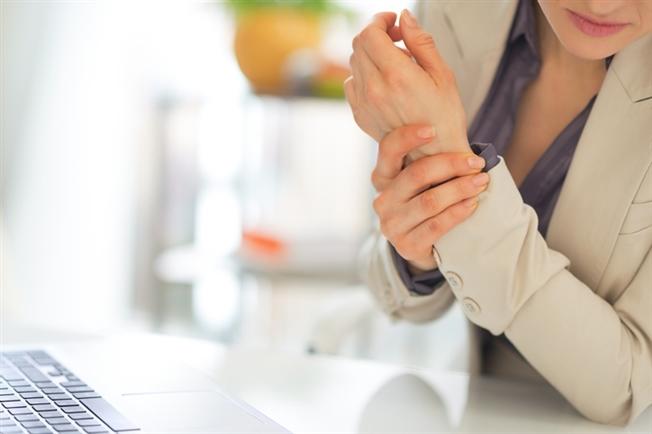 Woman grasping hand in pain