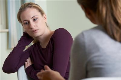 Teen sitting with adult having a serious conversation