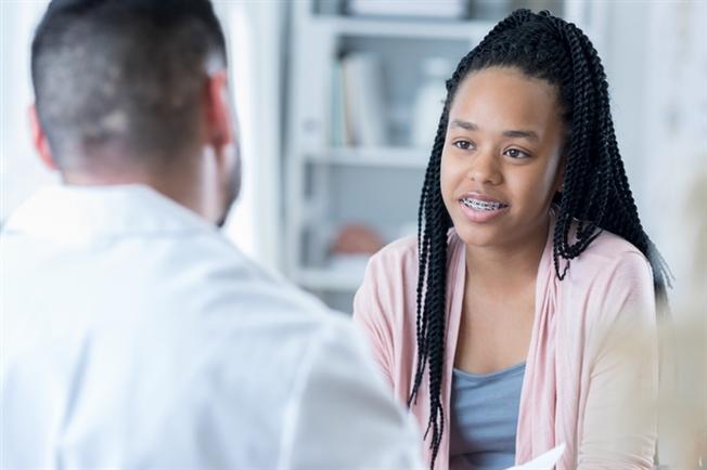Young woman talking with doctor
