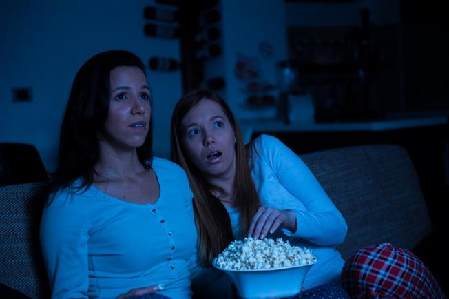 Two women watching tv together, horror movie Two women watching tv together, horror movie