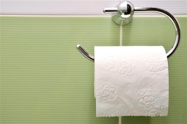 Roll of toilet paper hanging on wall holder Roll of toilet paper hanging on wall holder