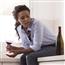 Woman sitting next to wine bottle with wine glass in hand
