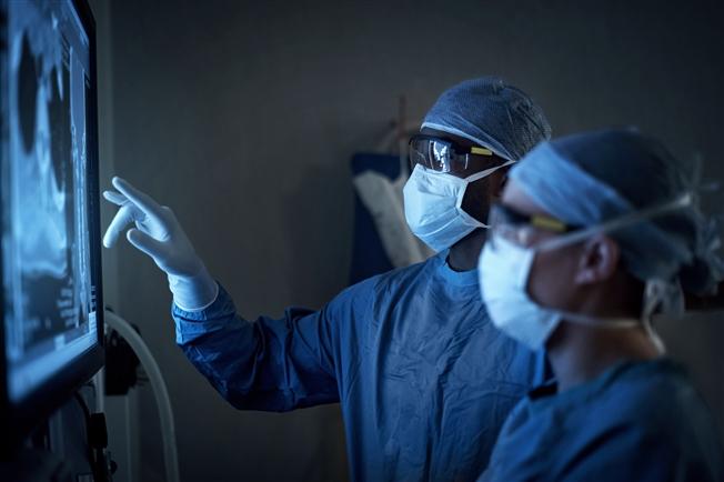 Two doctors looking at X-ray on the wall