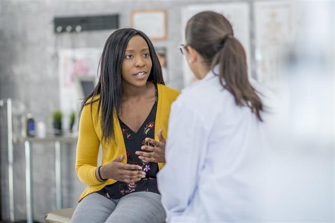 Woman sitting and talking with her doctor in an office