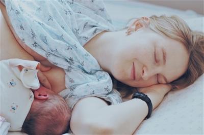 Mom laying on her side breastfeeding her newborn