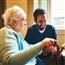 Younger person working with an older lady to show her how to use a tablet