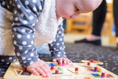 Baby playing with a baby puzzle on the ground Baby playing with a baby puzzle on the ground