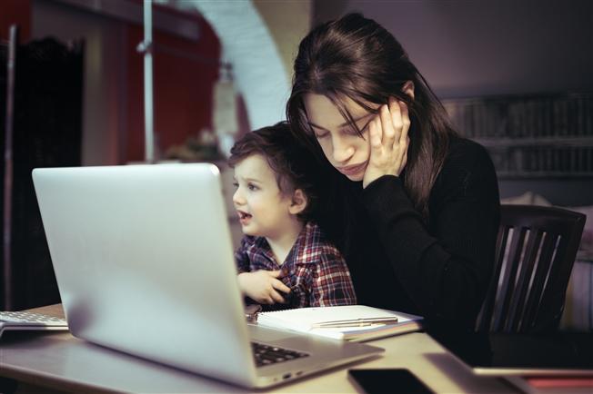 Tired mother holding son while trying to work Tired mother holding son while trying to work