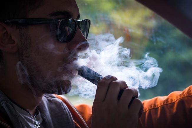 Young adult vaping while driving Young adult vaping while driving
