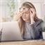 Woman rubbing eye at desk