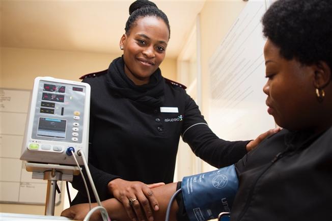 Woman taking patient's blood pressure