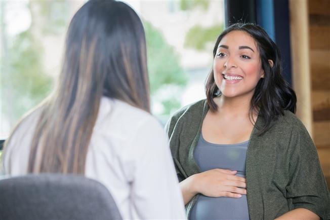 Pregnant woman talking to midwife