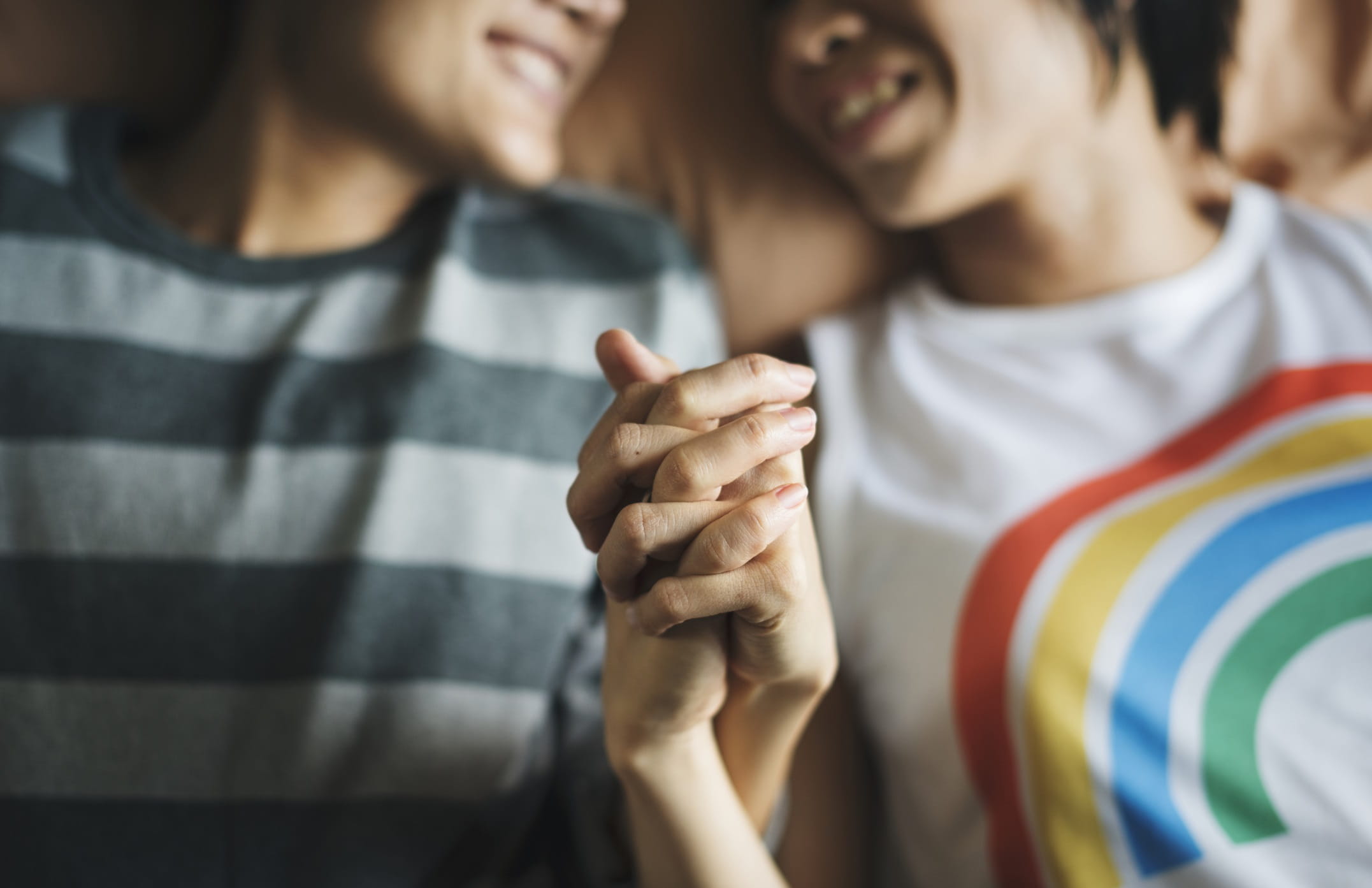 A couple holding their entwined hands up in front of camera A couple holding their entwined hands up in front of camera