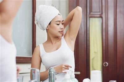 Woman holding her arm up to look at her armpit