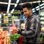 Man checking out fruit at a grocery store