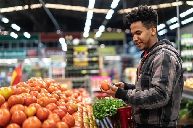 Man checking out fruit at a grocery store