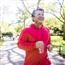 Man jogging outside, listening to something through earbuds and carrying a water bottle