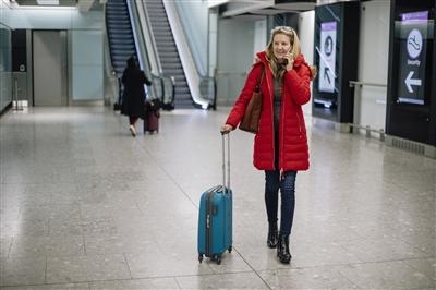 Woman walking through airport on phone