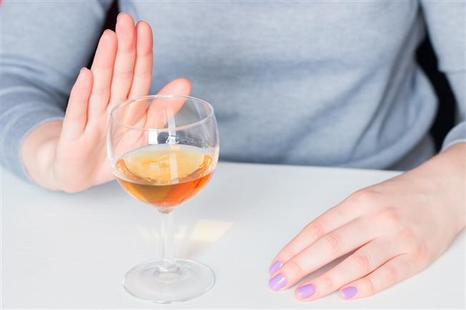 Close up on person refusing an alcoholic drink with a hand signal Close up on person refusing an alcoholic drink with a hand signal