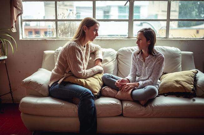 Mother talking to daughter on couch