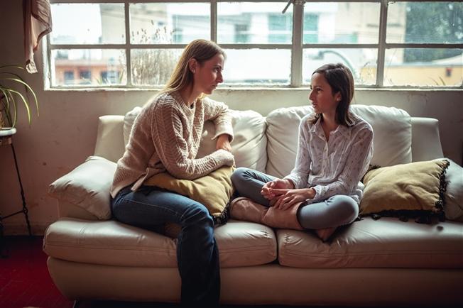 Mother talking to daughter on couch Mother talking to daughter on couch