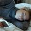 Woman looking sad scrolling phone in bed