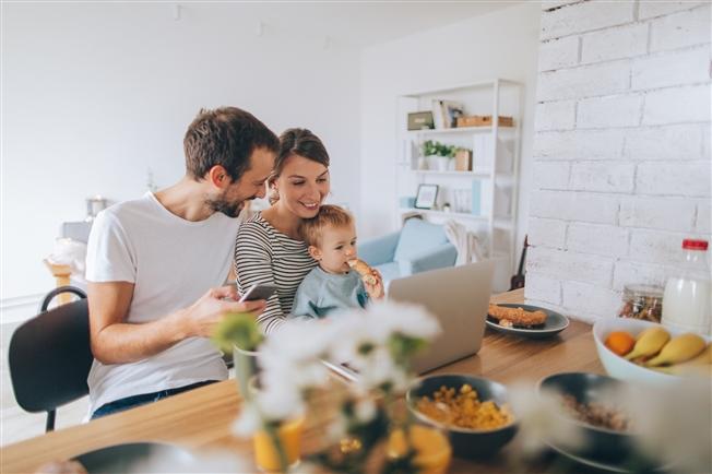 Young couple with infant son eating breakfast