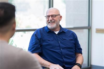 Cheerful man smiles during support group meeting Cheerful man smiles during support group meeting