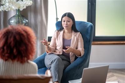 Professional female psychologist speaking with client