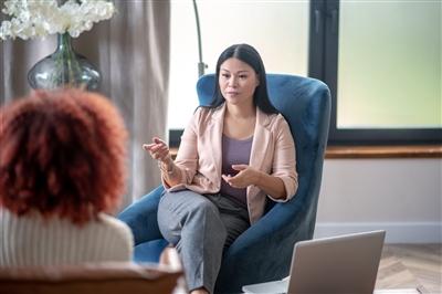 Professional female psychologist speaking with client Professional female psychologist speaking with client