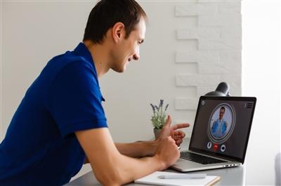 Man having video chat with doctor at home Man having video chat with doctor at home