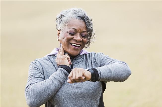 Senior woman exercising taking pulse